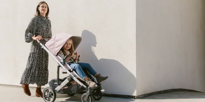 Woman pushing child in an UPPAbaby CRUZ V2 Stroller