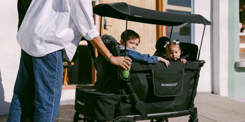Children outside in the WonderFold L4 wagon from WonderFold