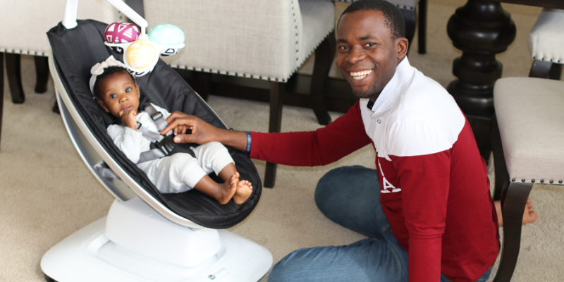 Dad playing with baby sitting in a 4moms swing