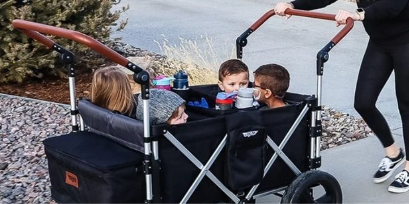 Woman Pushing the Keenz 7S+ 4 Passenger Stroller Wagon With Four Kids Sitting Inside