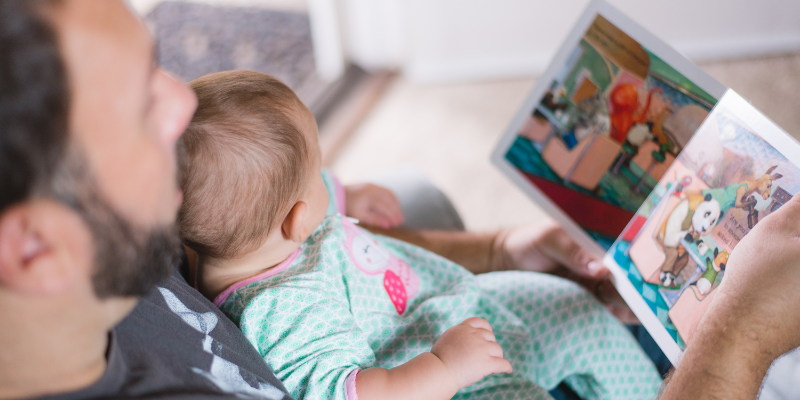 Man Reading Children's Book to Baby 