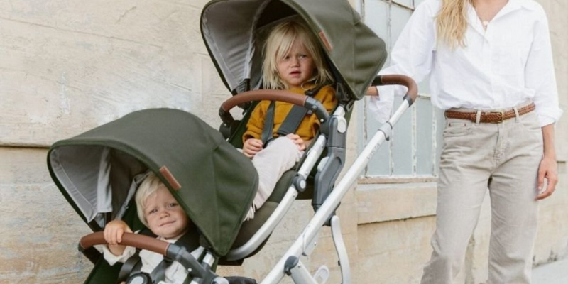 Woman pushing two children in the UPPAbaby VISTA V2 Stroller