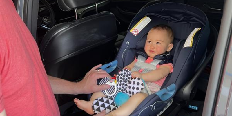Baby Sitting in Cybex Aton G Swivel Infant Car Seat Facing 180 Degrees Towards Adult 