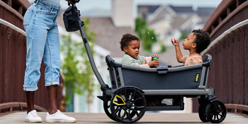 Woman Walking While Pushing Children Sitting In Veer Cruiser Wagon