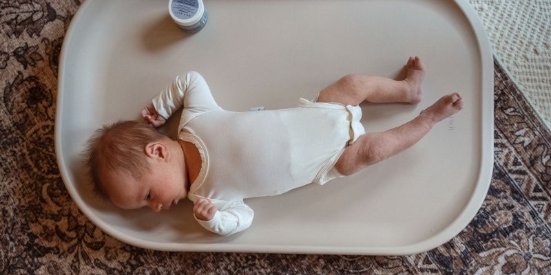 Baby lying on Townsend Avenue wipeable changing pad during diaper change