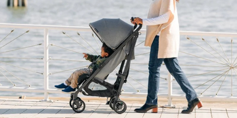 Mom pushing UPPAbaby G-Luxe V2 Stroller on boardwalk