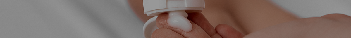 Mother putting Attitude lotion on tip of finger to apply to baby