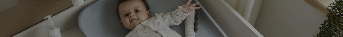 Baby laying on a Leader Matty Changer in blue on top of nursery dresser