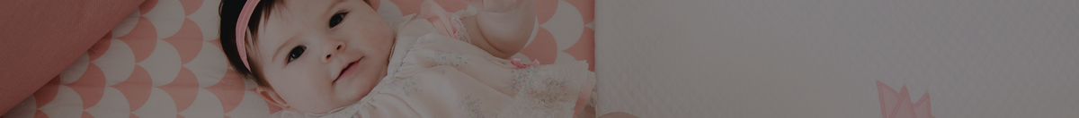 Baby laying in their crib on a Lolli Living crib sheet