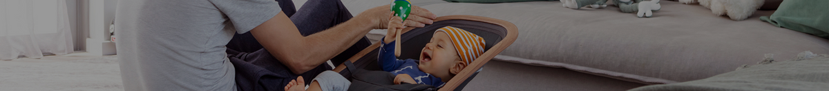 Father playing with smiling baby in a Maxi-Cosi Kori Rocker