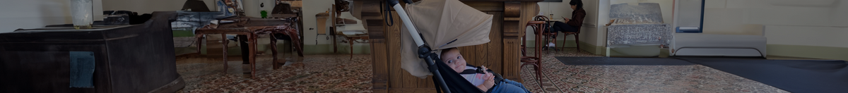 Little girl at a coffee shop smiling, while sitting in a BABYZEN YOYO2 compact & lightweight stroller