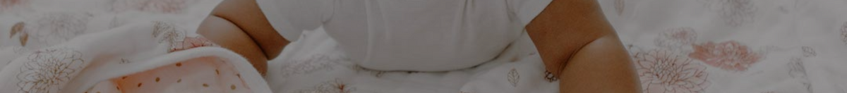 Baby laying on an aden + anais quilted silky soft blanket
