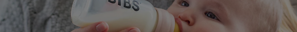 Baby feeding out of a BIBs bottle feeder with a slow-flow nipple attached