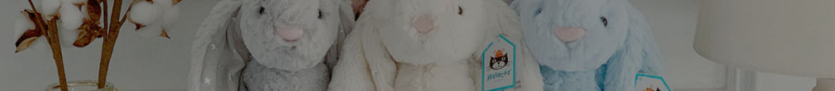 Colourful Jellycat bunnies sitting on a bedroom shelf