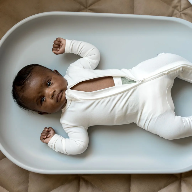 Baby lying on Townsend Avenue wipeable changing pad during diaper change