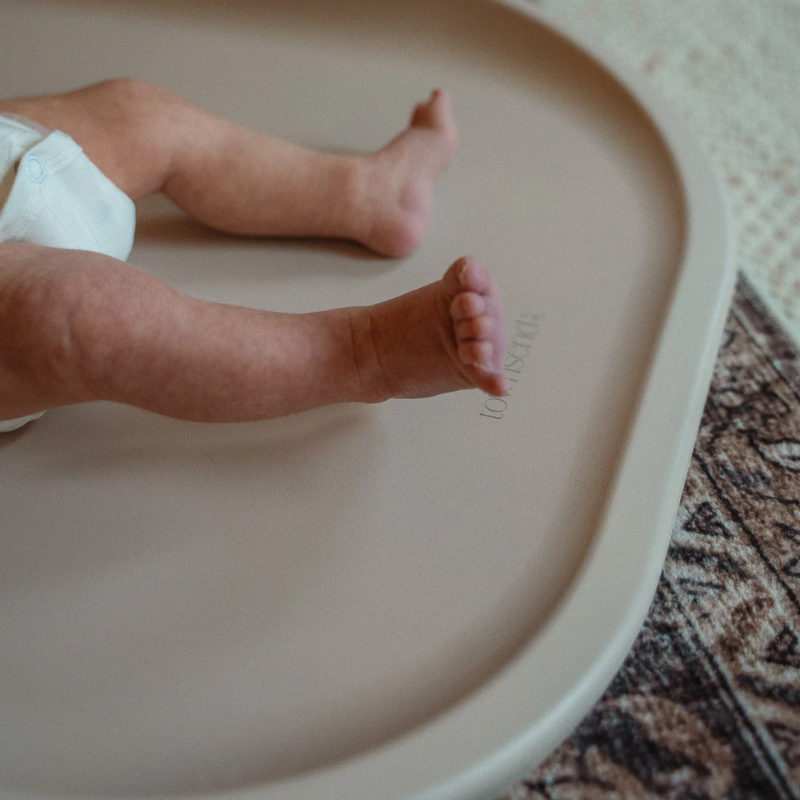 Baby's feet on a beige surface with a blurred background